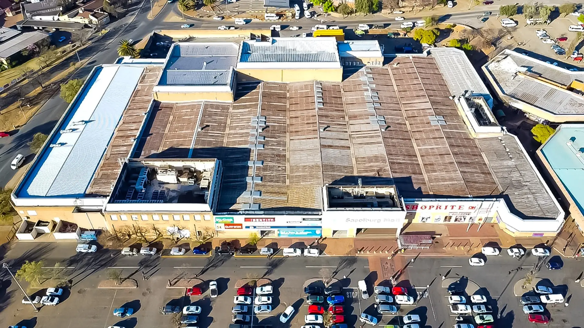 Neglected commercial roof with blocked gutters and early rust in Gauteng